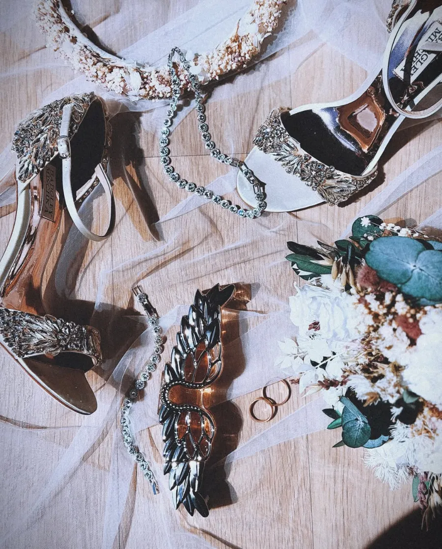 Sapatos, joias e alianças sobre tecido rendado