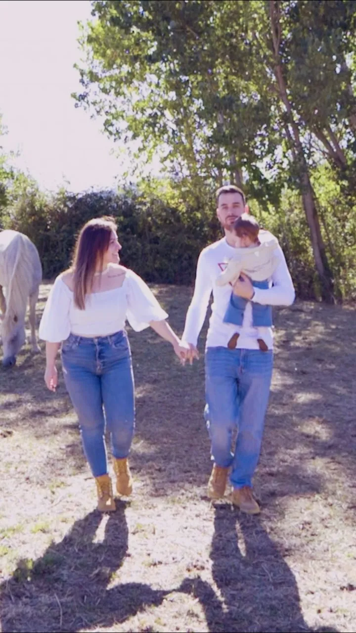 Casal a caminhar num caminho de terra com a filha ao colo